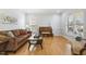 Comfortable living room featuring hardwood floors, a couch, piano, and natural light at 8215 Cushing St, Raleigh, NC 27613