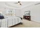 Bright main bedroom featuring a tray ceiling, ceiling fan, and large window with natural light at 8215 Cushing St, Raleigh, NC 27613