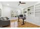 Home office featuring hardwood floors, a large window, built-in bookshelves, and a ceiling fan at 8215 Cushing St, Raleigh, NC 27613