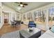 Well-lit sunroom featuring a seating area, dining space, and views of the fenced backyard at 8215 Cushing St, Raleigh, NC 27613