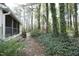 Side view of a home surrounded by lush trees and greenery, enhancing the home's privacy and appeal at 8310 Wycombe Ln, Raleigh, NC 27615