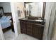 Bathroom with granite double vanity, dark wood cabinetry, and tile floors adjacent to the main bedroom at 8310 Wycombe Ln, Raleigh, NC 27615