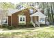 Charming brick home with cream trim, a cozy front porch, and manicured front lawn at 8310 Wycombe Ln, Raleigh, NC 27615