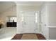 Bright and inviting foyer features a white door and decorative rug over hardwood flooring at 8310 Wycombe Ln, Raleigh, NC 27615