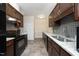 A kitchen featuring granite countertops, dark wood cabinets, a tile backsplash, and stainless steel appliances at 8310 Wycombe Ln, Raleigh, NC 27615