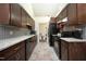A beautifully renovated kitchen with dark wood cabinets, granite countertops, and stainless steel appliances at 8310 Wycombe Ln, Raleigh, NC 27615