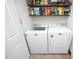 Functional laundry room features a washer, dryer, and shelving for organized storage of laundry supplies at 8310 Wycombe Ln, Raleigh, NC 27615
