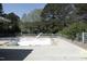 An empty pool surrounded by trees, with a sunny sky above, showcasing the potential for outdoor enjoyment at 8310 Wycombe Ln, Raleigh, NC 27615