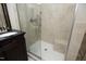 Bathroom featuring an updated shower with glass door, a built in bench and neutral colored tiles at 8310 Wycombe Ln, Raleigh, NC 27615