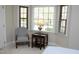 Sitting area with chair and lamp next to the bay window in the main bedroom, carpeted flooring, natural light at 8310 Wycombe Ln, Raleigh, NC 27615