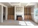 Unfinished living room featuring built-in bookshelves and a fireplace, offering a customizable space with natural light at 835 Emmett Ct, Spring Hope, NC 27882