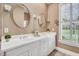 Bright bathroom with a double vanity, white cabinetry, large mirror and natural light from a window at 10 E Madison, Pittsboro, NC 27312