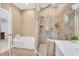 Well-lit bathroom featuring glass enclosed shower, soaking tub, and white cabinetry at 10 E Madison, Pittsboro, NC 27312