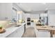 Well-lit kitchen featuring white cabinets, stainless steel appliances, and a central island cooktop at 10 E Madison, Pittsboro, NC 27312