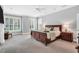 Spacious bedroom with hardwood sleigh bed, neutral walls, ceiling fan and bright windows with shutters at 10 E Madison, Pittsboro, NC 27312