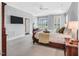 Spacious primary bedroom with ample natural light, a TV, and a ceiling fan at 10 E Madison, Pittsboro, NC 27312