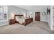 A large main bedroom features light gray walls, a ceiling fan, shuttered windows and wooden furniture at 10 E Madison, Pittsboro, NC 27312