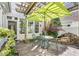 Picturesque patio area with a pergola, outdoor seating, lush plants, and a rock water feature at 10 E Madison, Pittsboro, NC 27312