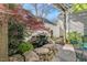 Serene patio with a rock waterfall, lush greenery, and a manicured garden at 10 E Madison, Pittsboro, NC 27312