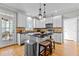 Bright kitchen features stainless appliances, white cabinets, hardwood floors, and kitchen island with seating at 101 Barriedale Cir, Cary, NC 27519