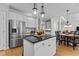 Open kitchen features stainless steel appliances, granite countertops, an island, and an adjacent dining area at 101 Barriedale Cir, Cary, NC 27519