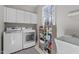 Convenient laundry room with modern appliances, built-in storage, utility sink, and a large window at 101 Barriedale Cir, Cary, NC 27519