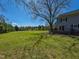 Sprawling backyard with a lush green lawn and mature trees under a blue sky at 10317 Lake Wheeler Rd, Fuquay Varina, NC 27526