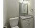 Half bathroom featuring a granite vanity, modern lighting, and a toilet in a compact space at 10317 Lake Wheeler Rd, Fuquay Varina, NC 27526