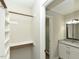 Walk-in closet adjacent to a bathroom with granite countertops and modern fixtures at 10317 Lake Wheeler Rd, Fuquay Varina, NC 27526
