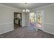 Dining room adjacent to kitchen with carpeted flooring, patio access and modern lighting fixture at 10317 Lake Wheeler Rd, Fuquay Varina, NC 27526
