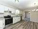 Bright kitchen featuring white cabinetry, stainless steel appliances, and luxury vinyl plank flooring at 10317 Lake Wheeler Rd, Fuquay Varina, NC 27526