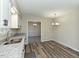 Eat-in kitchen featuring stainless steel sink, granite countertops, wood-look flooring, and modern lighting at 10317 Lake Wheeler Rd, Fuquay Varina, NC 27526