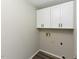 Functional laundry room with upper cabinets and utility connections, featuring modern flooring at 10317 Lake Wheeler Rd, Fuquay Varina, NC 27526