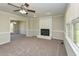 Spacious living room featuring neutral walls, carpet, and a white painted brick fireplace at 10317 Lake Wheeler Rd, Fuquay Varina, NC 27526