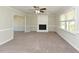 Spacious living room featuring neutral walls, carpet, and a white painted brick fireplace at 10317 Lake Wheeler Rd, Fuquay Varina, NC 27526
