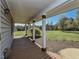 Covered porch featuring wood decking, support columns, and views of the surrounding yard at 10317 Lake Wheeler Rd, Fuquay Varina, NC 27526