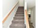 Carpeted staircase with a wooden handrail, leading to the upper level, and nearby kitchen at 10317 Lake Wheeler Rd, Fuquay Varina, NC 27526
