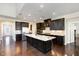Spacious kitchen featuring island, stainless appliances, dark cabinets, and ample lighting at 104 Bailey Park Ct, Cary, NC 27513