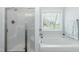 Bright bathroom features a tub, shower, and window at 105 Village Dr, Broadway, NC 27505