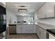 Open kitchen features granite countertops, stainless steel appliances, gray cabinets, and island with sink at 105 Village Dr, Broadway, NC 27505