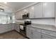 Modern kitchen with stainless steel appliances, gray cabinets, granite countertops, and subway tile backsplash at 105 Village Dr, Broadway, NC 27505