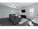 Cozy living room featuring a comfortable gray sofa, a ceiling fan, and natural light at 105 Village Dr, Broadway, NC 27505
