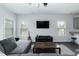 Comfortable living room with a gray sofa, a ceiling fan, and natural light from the windows at 105 Village Dr, Broadway, NC 27505