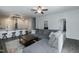 Open-concept living area with a large gray sofa, kitchen bar seating, and modern lighting at 105 Village Dr, Broadway, NC 27505