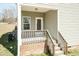 Well-maintained porch with wooden steps, brick foundation, and a stylish covered entry at 105 Village Dr, Broadway, NC 27505