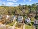 An aerial view of a neighborhood featuring manicured lawns, mature trees, and a blue sky background at 1052 Mills Street, Raleigh, NC 27608