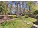 A spacious backyard featuring green grass, mature trees, and a storage shed at 1052 Mills Street, Raleigh, NC 27608