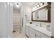Clean bathroom with white cabinets, a well-lit mirror, and a shower curtain in the background at 1052 Mills Street, Raleigh, NC 27608