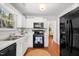 Eat-in kitchen with view to living area and backyard, offering updated appliances and hardwood flooring at 1052 Mills Street, Raleigh, NC 27608