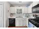 Bright kitchen features white cabinets, black appliances, and a window over the sink with a view at 1052 Mills Street, Raleigh, NC 27608